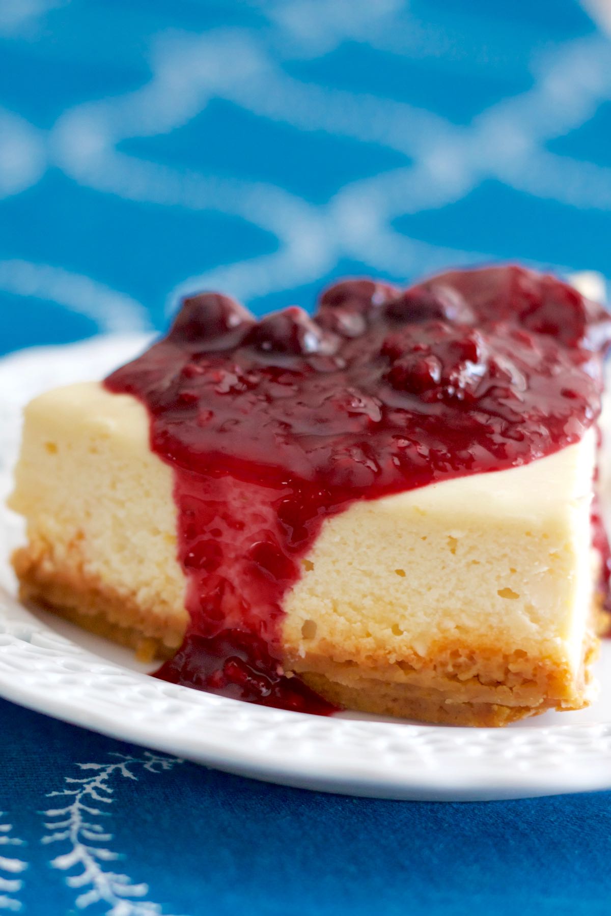 A slice of Classic Cheesecake Mixed Berries Sauce on a plate.