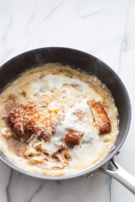 Katsudon is basically katsu (a pork chop breaded with panko and fried) paired with a slightly sweet mixture of egg and onion, laid over Japanese rice. | www.SpoonfulOfButter.com
