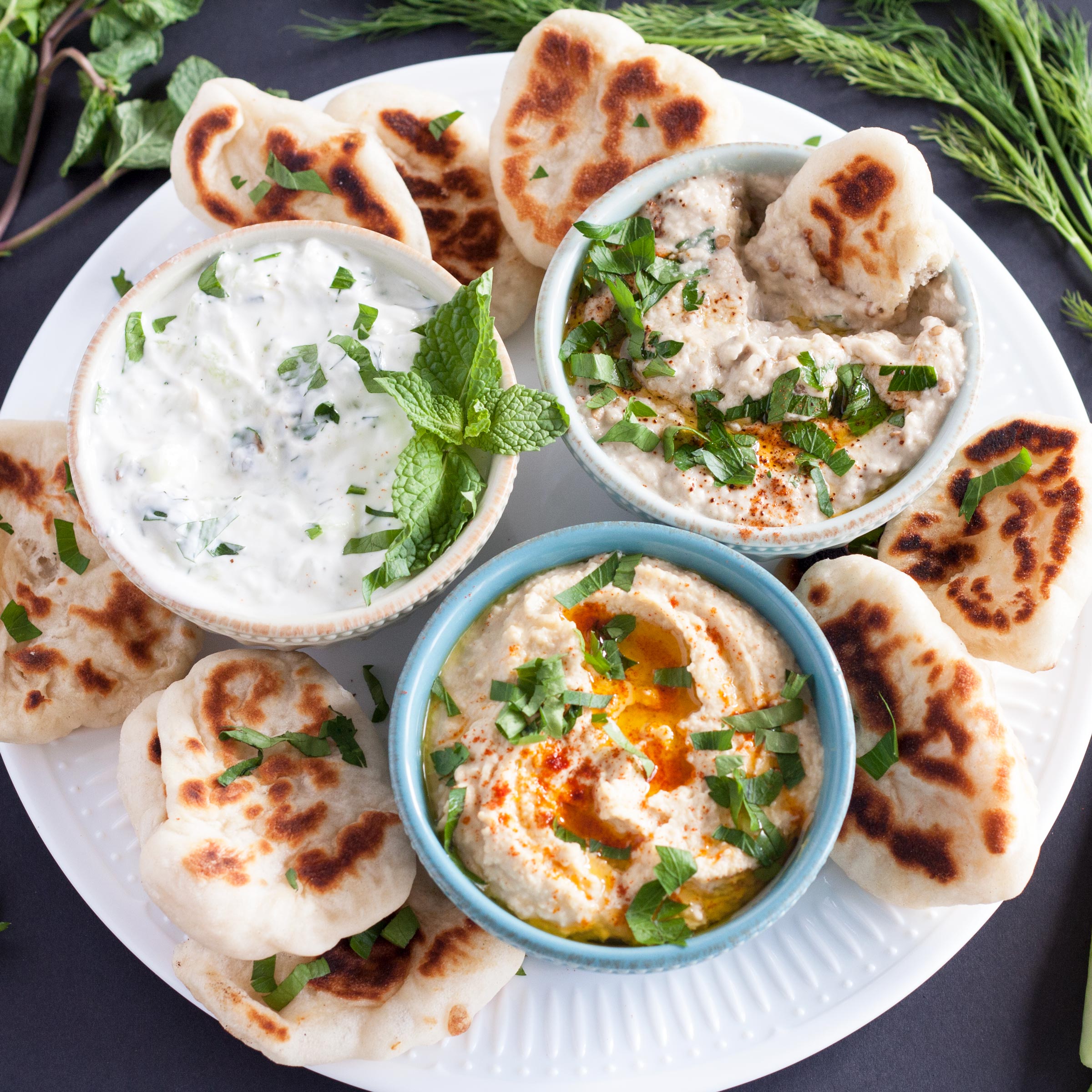 A Mezze Platter consists of Hummus, Baba Ganoush, Tzatziki, and Naan Dippers