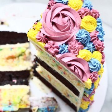 a slice of cake with colorful buttercream frosting
