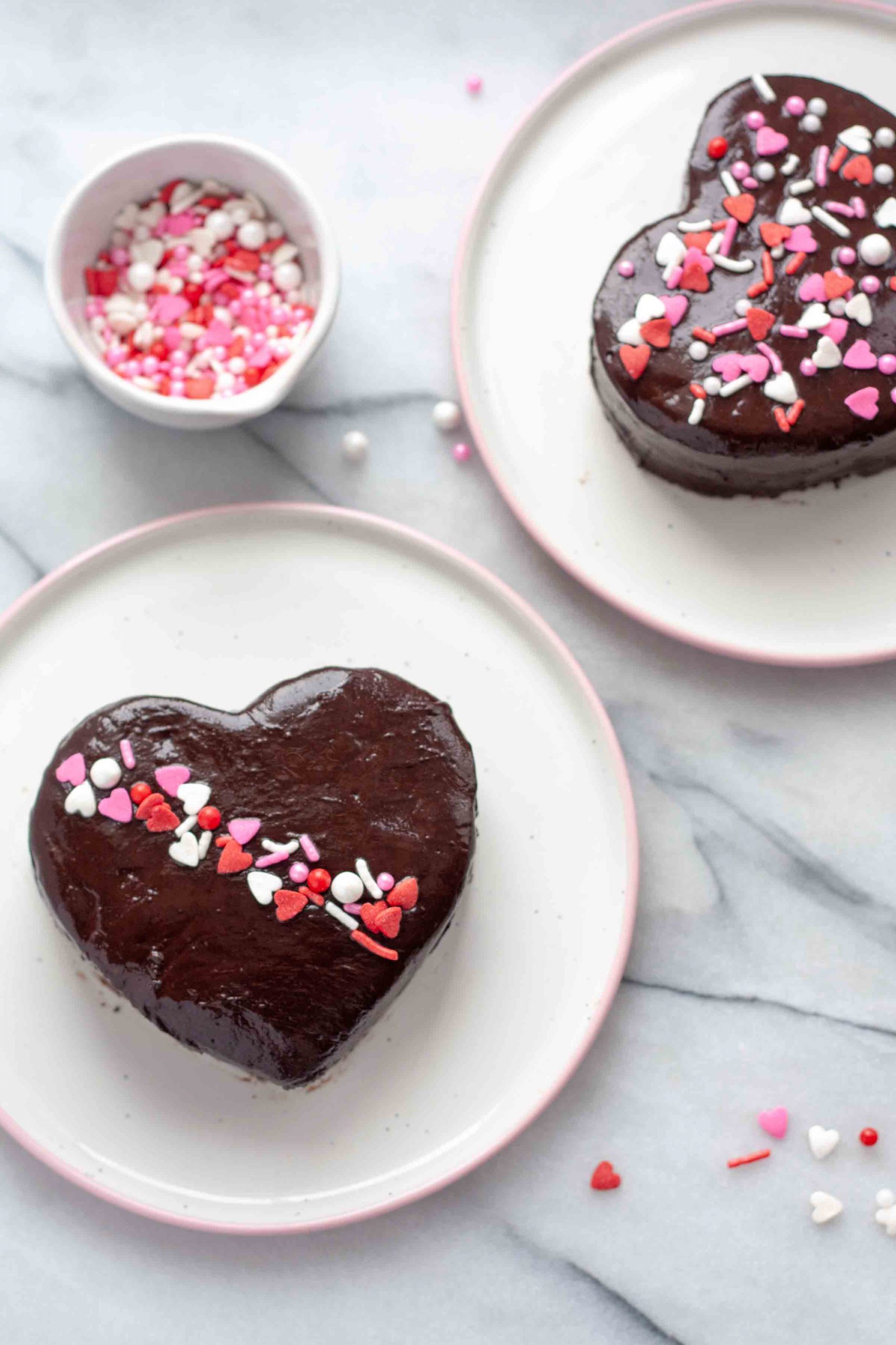 two chocolate ganache hearts with a bowl of sprinkles