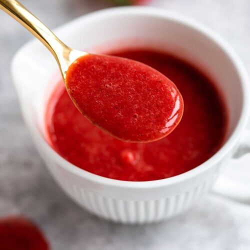 Strawberry Coulis scooped in a golden spoon