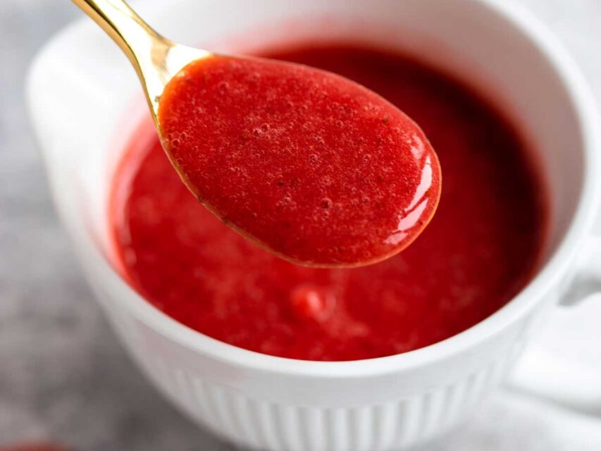 Strawberry Coulis scooped in a golden spoon
