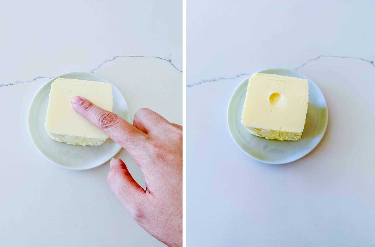 A small block of butter showing an slight indent after pressing one finger on it.