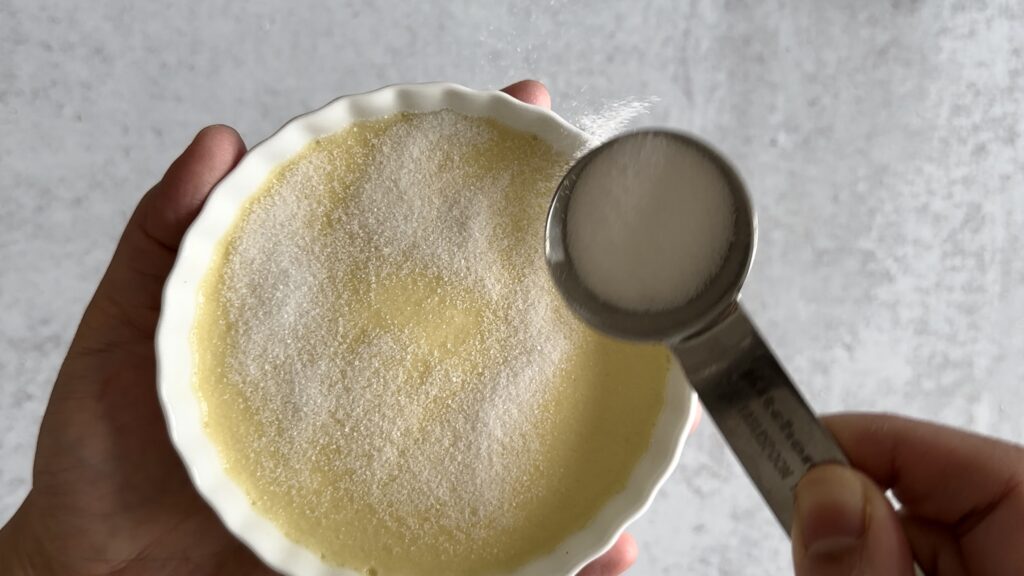 sprinkling sugar on each creme brulee