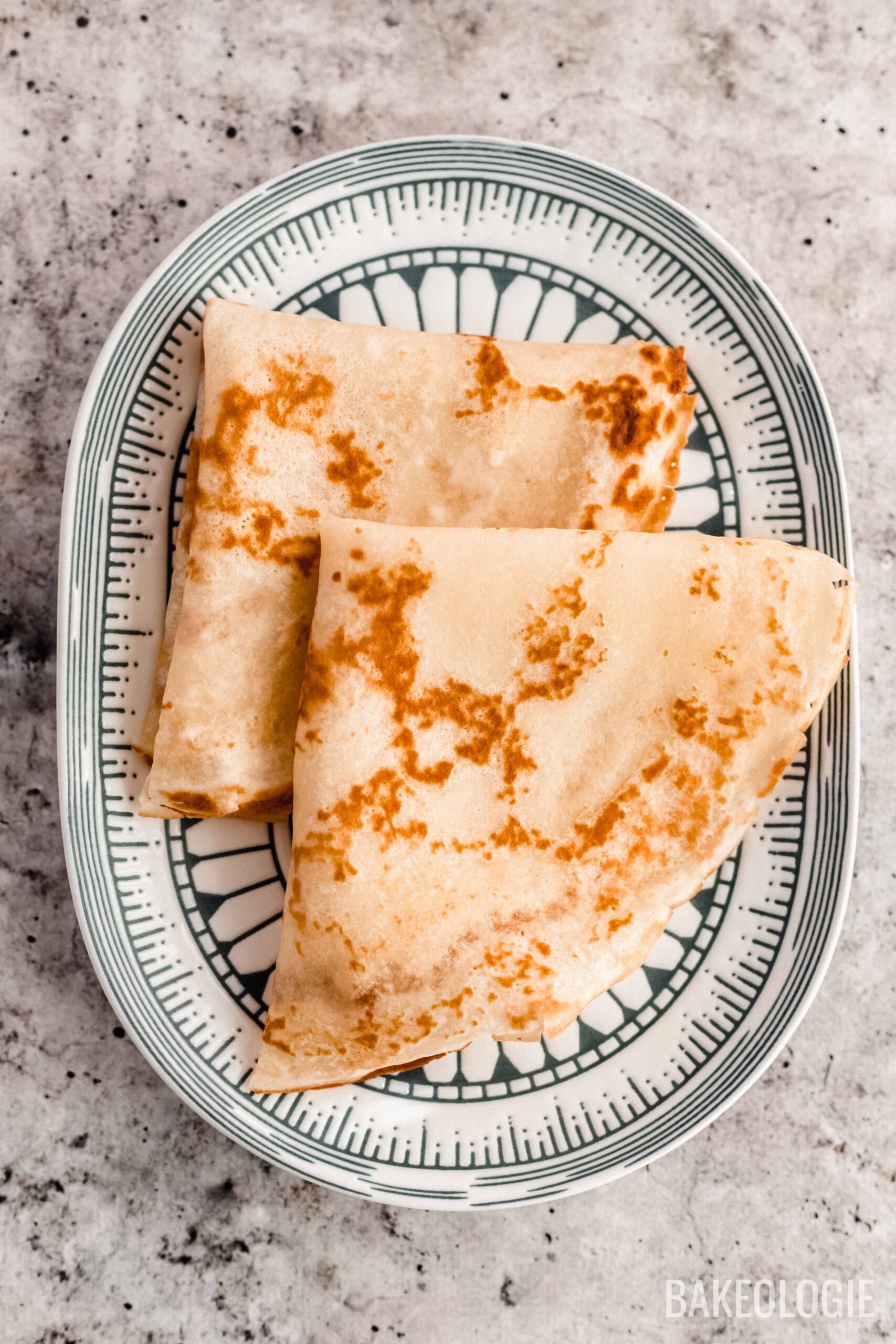 folded lacy French crepes on an oval plate