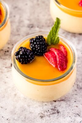 mango mousse decorated with blackberries, strawberries, and mint leaves.