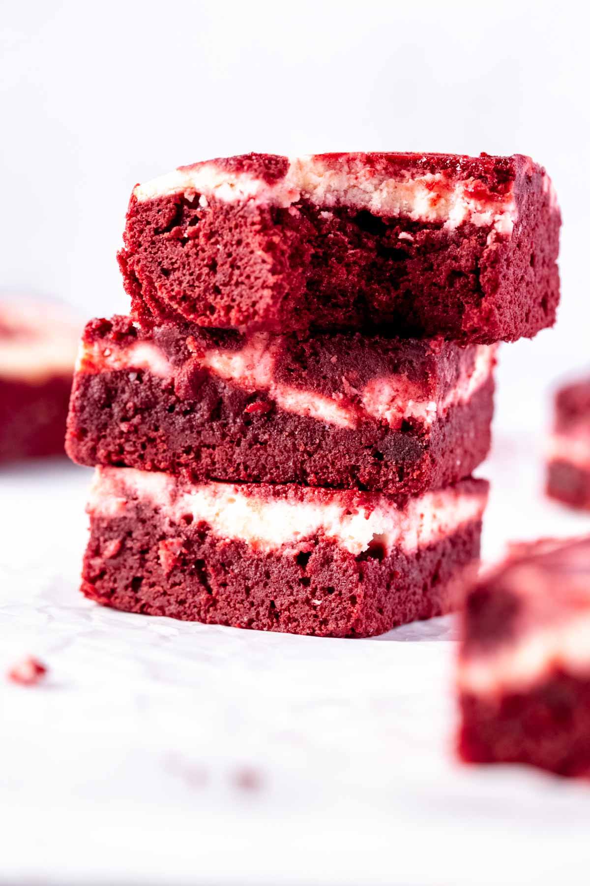 stack of slice red velvet cream cheese swirl brownies with a bite