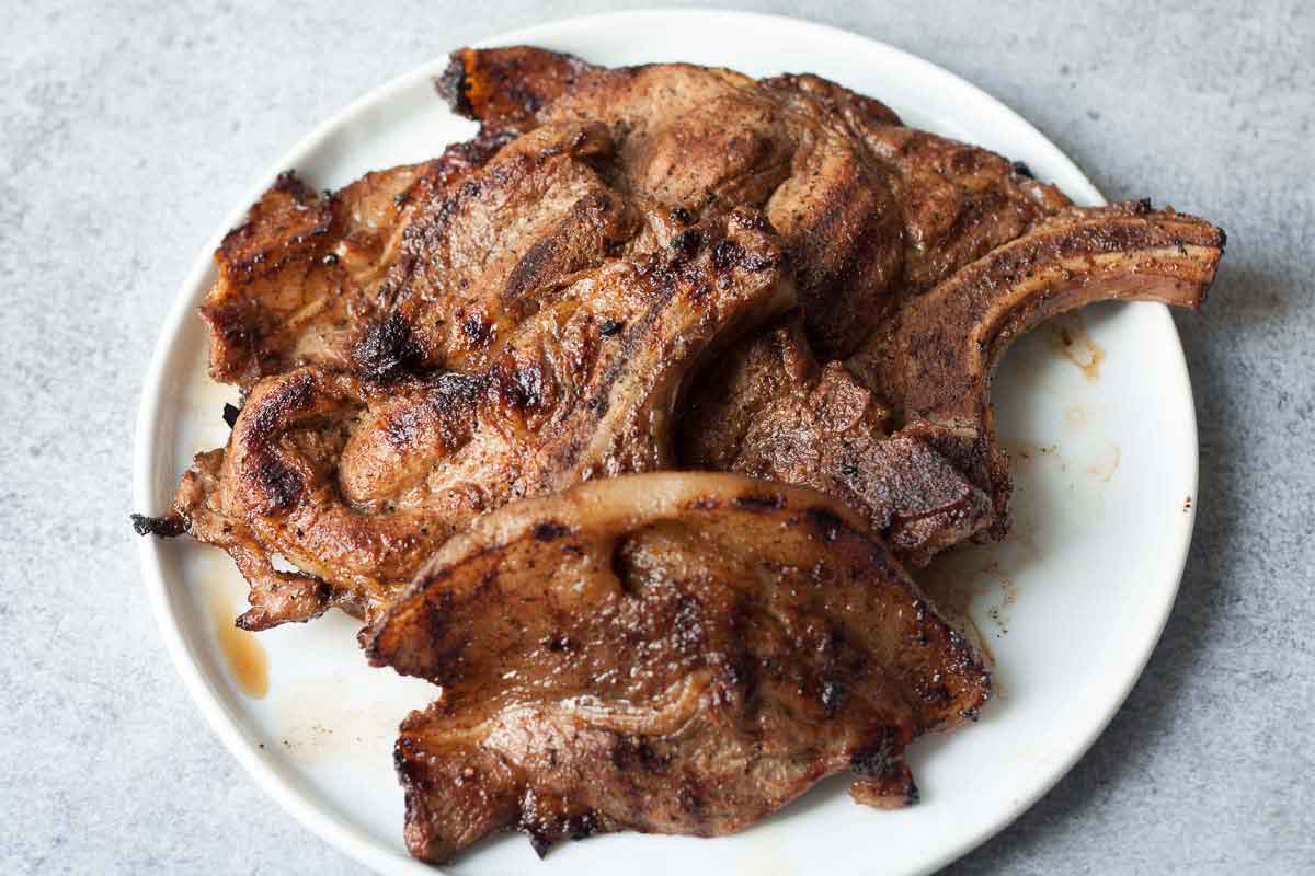 juicy pork chops on a white, round plate