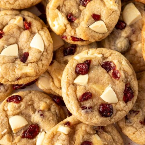 Close-up view of white chocolate cranberry cookies with golden brown edges, studded with chunks of white chocolate and dried cranberries.