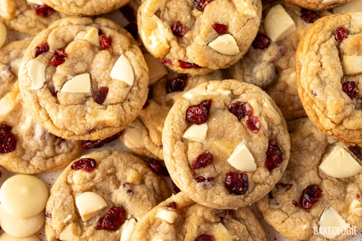 Close-up view of white chocolate cranberry cookies with golden brown edges, studded with chunks of white chocolate and dried cranberries.