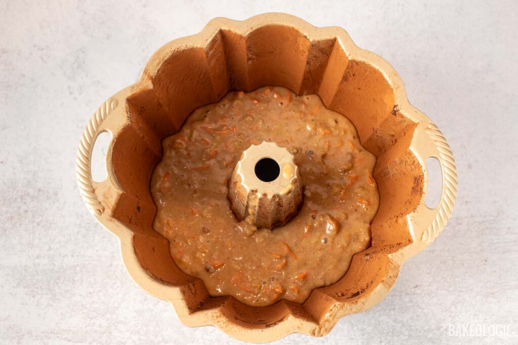 Carrot cake batter poured into a Bundt pan, nearly filled to the top, ready for baking