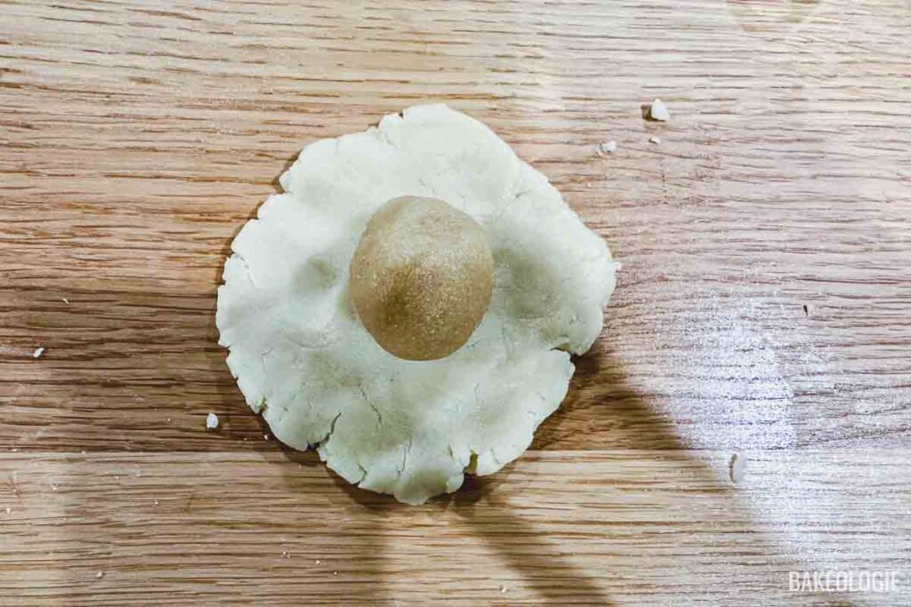 a flattened dough with about a tablespoon of almond filling