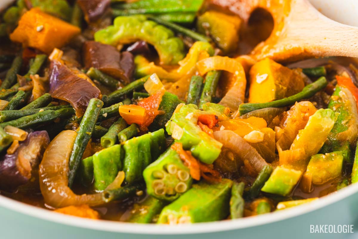 Close-up of a Filipino Pinakbet recipe — a colorful vegetable stew made with okra, eggplant, bitter melon, long beans, squash, and tomatoes simmered in shrimp paste.