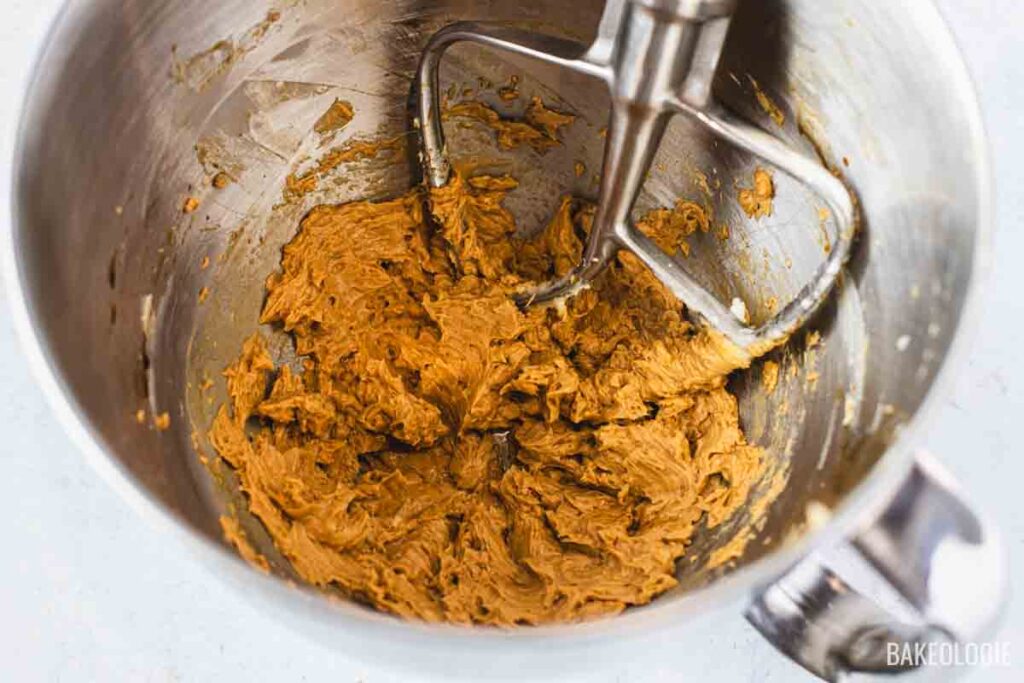 Butter mixed with the dissolved coffee and sugar, creating a light brown, fluffy coffee-butter mixture.