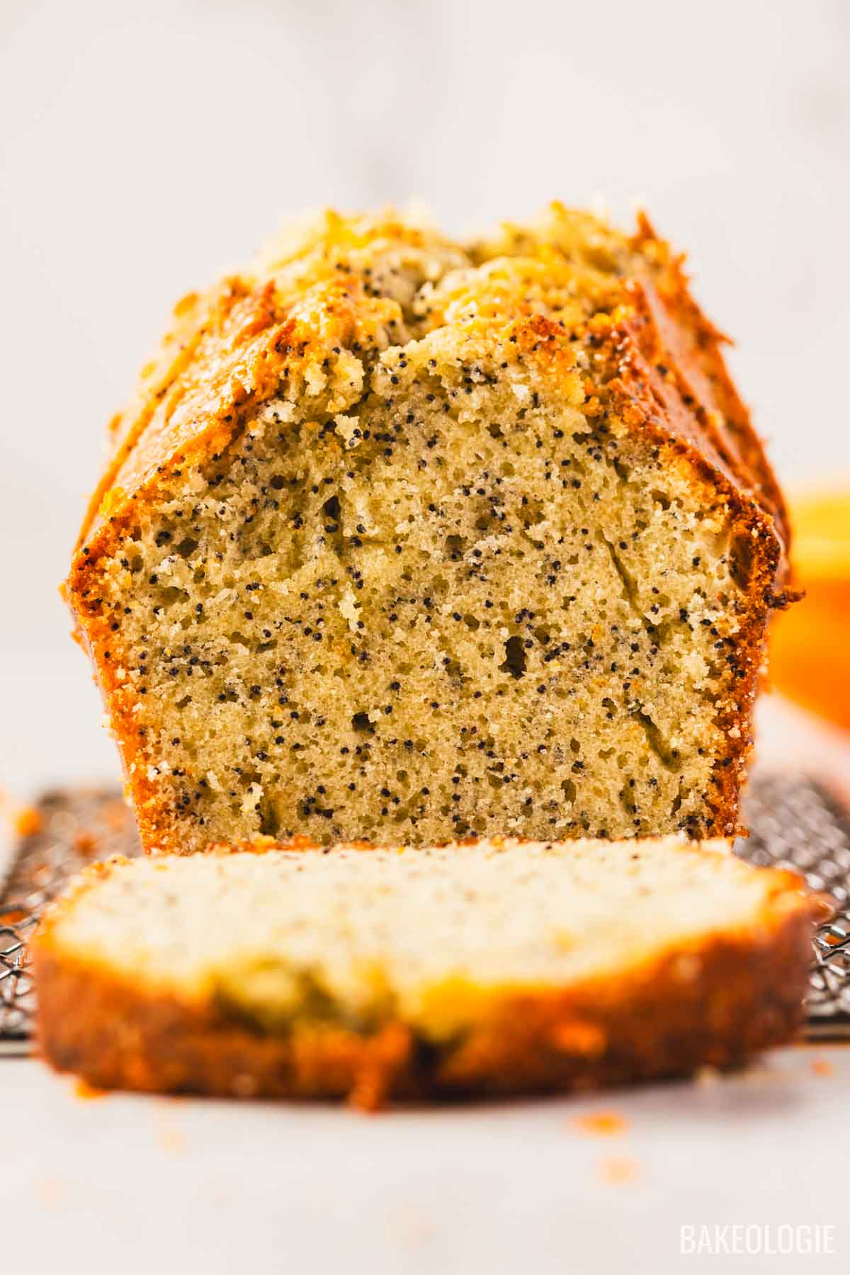 Close-up of orange poppyseed loaf cake showing moist, speckled crumb
