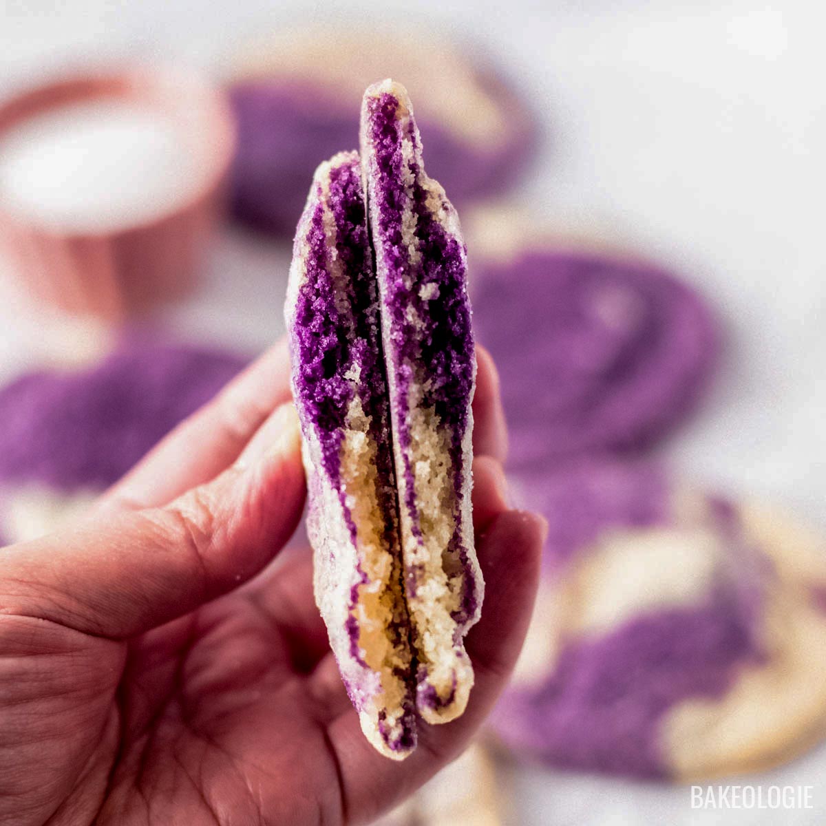 Marbled ube cookie broken in half showing a soft and chewy purple ube and vanilla interior