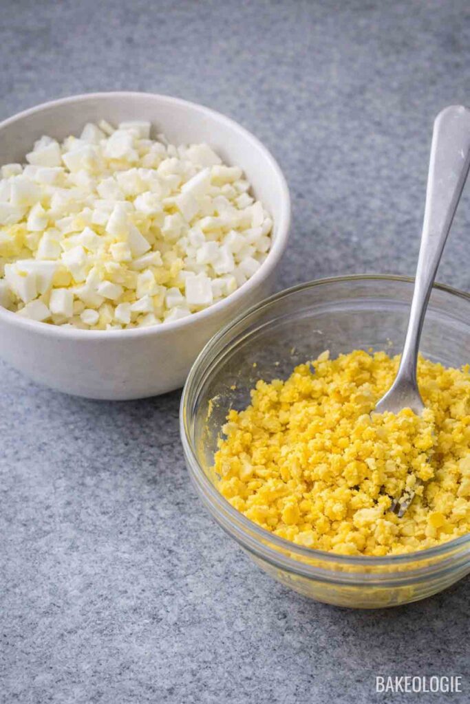 Chopped egg whites and mashed egg yolks in separate bowls for Korean potato salad