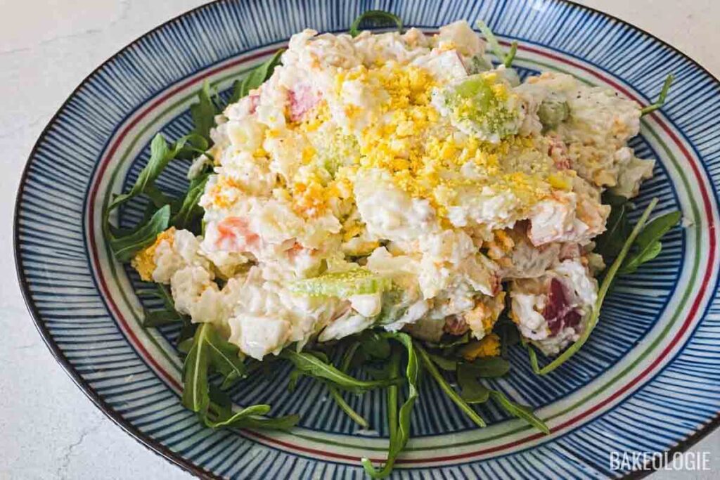 Korean potato salad topped with fluffy mashed egg yolks on a serving plate