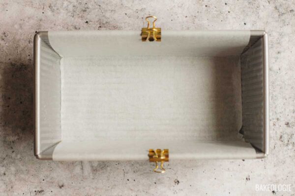 8.5 x 4.5-inch loaf pan lined with parchment paper for easy removal of cream cheese pound cake.