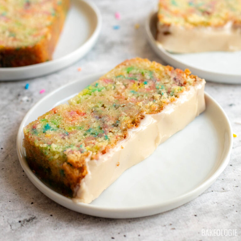 Close-up of Funfetti Sour Cream Pound Cake showing its moist crumb, colorful sprinkles, and vanilla glaze.