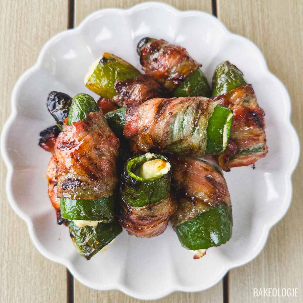 Top view of cream cheese bacon-wrapped jalapeño poppers cooked until the bacon is crispy and caramelized.