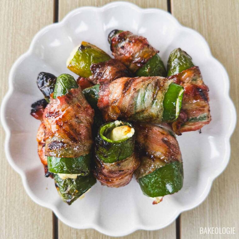 Top view of cream cheese bacon-wrapped jalapeño poppers cooked until the bacon is crispy and caramelized.
